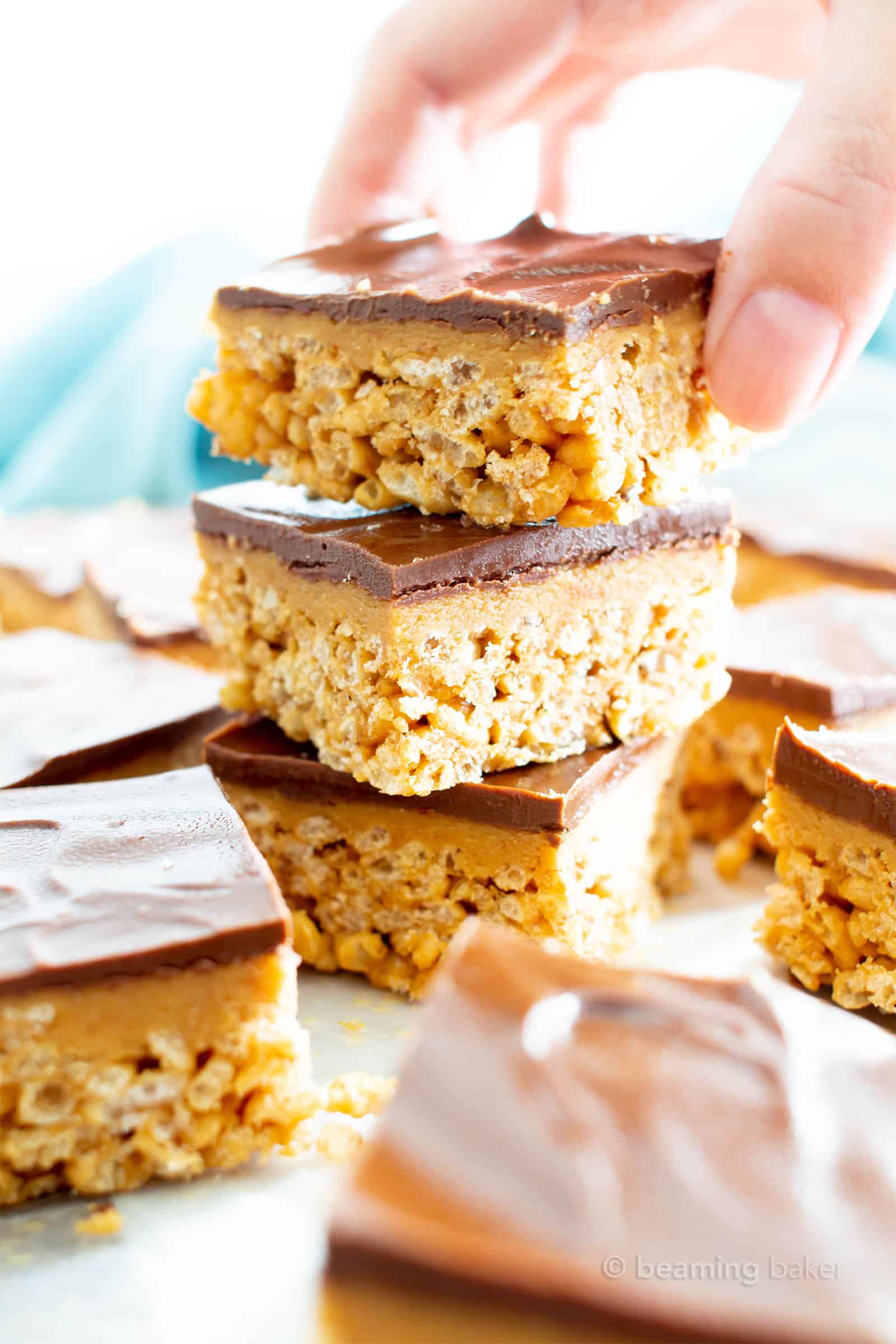 stack of peanut butter rice crispy treats, with a hand reaching for one