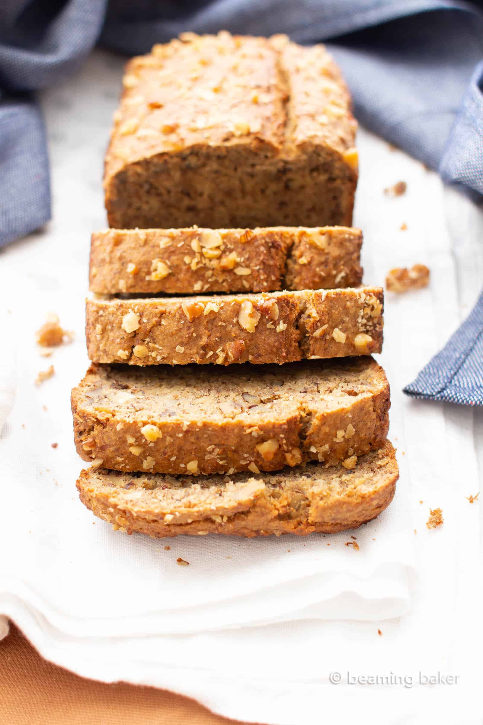 Front view of vegan gluten free banana bread loaf with slices falling forward