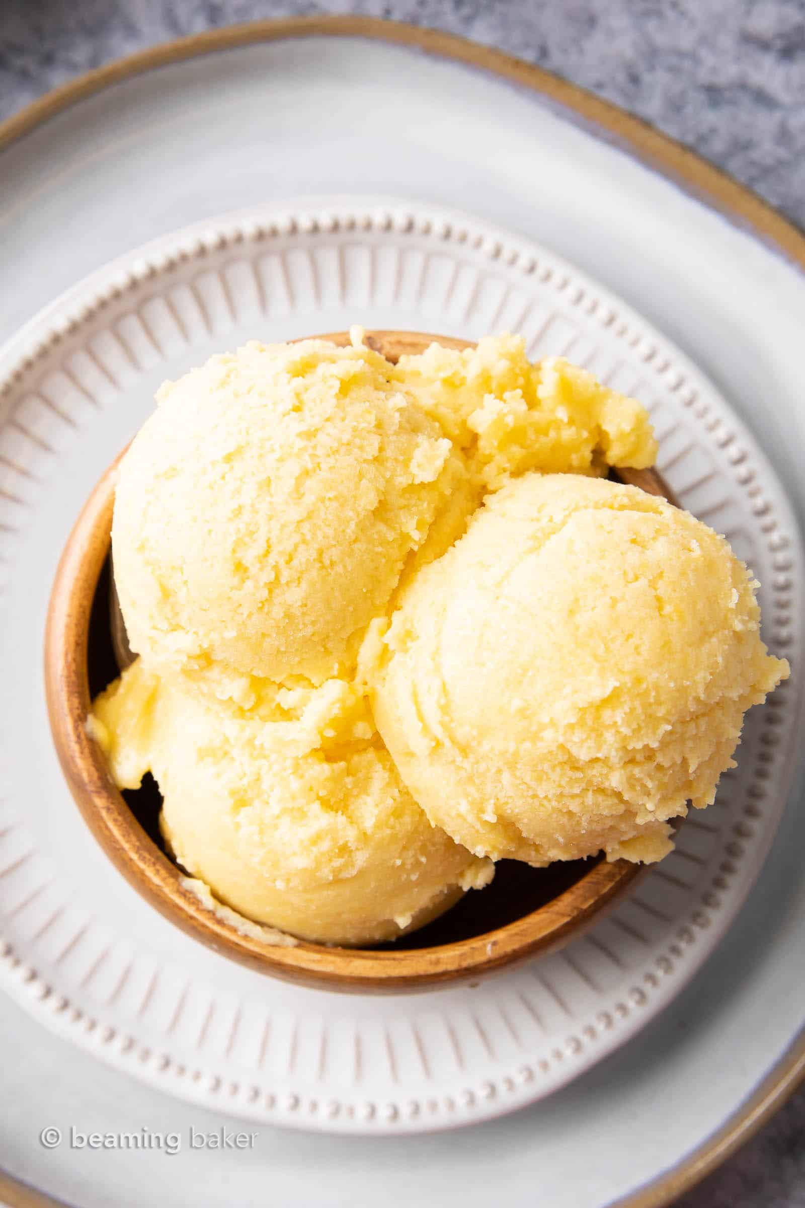 Overhead view of bowl with mango ice cream scoops in it.