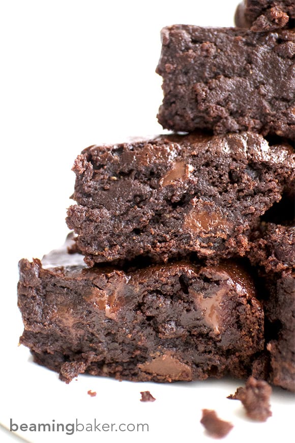 Closeup of stacked fudgy vegan brownies with chocolate melting on the sides