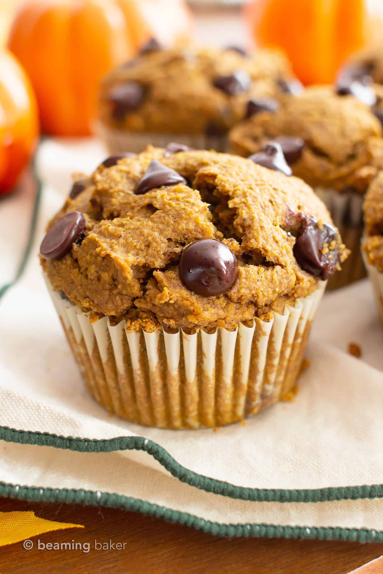 pumpkin chocolate chip muffins on a cream and green cloth