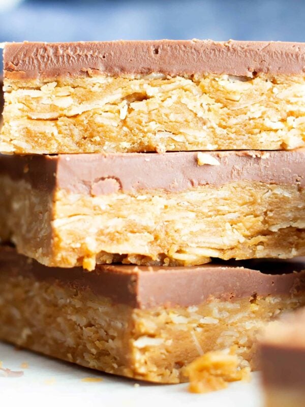 4 Ingredient Healthy No Bake Peanut Butter Cup Oat Bars: this vegan peanut butter oatmeal bars recipe is so easy to make & tastes like peanut butter cups! Chewy peanut butter oatmeal bars with a thick, chocolate topping. #Vegan #GlutenFree #Healthy #PeanutButter #Oats #Oatmeal | Recipe at BeamingBaker.com