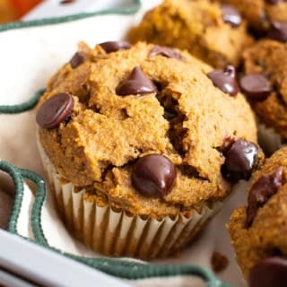 A closeup shot of pumpkin chocolate chip muffins in a basket