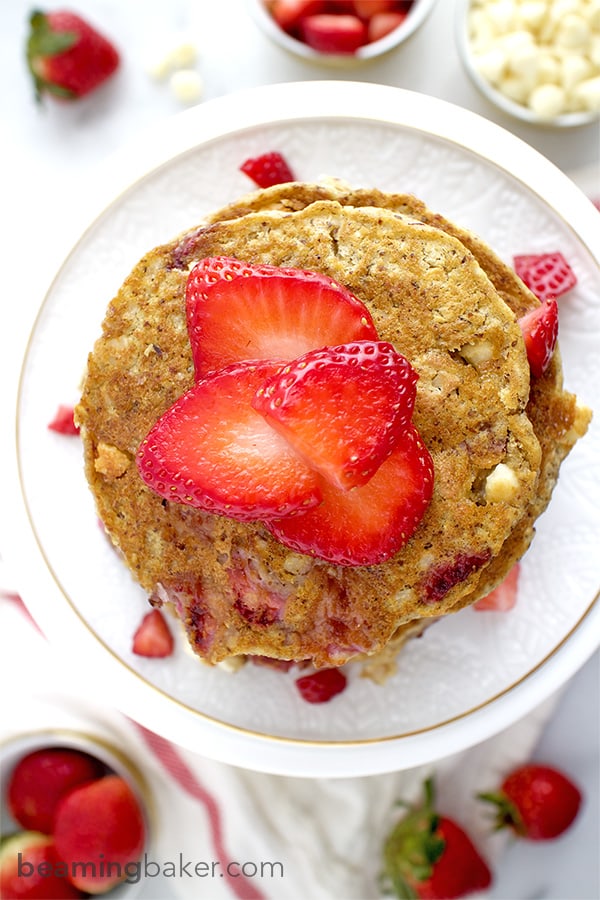 An easy recipe for the BEST fluffy strawberry white chocolate chip pancakes! Made with simple ingredients: oat flour, almond meal, whole wheat flour and coconut. BEAMINGBAKER.COM