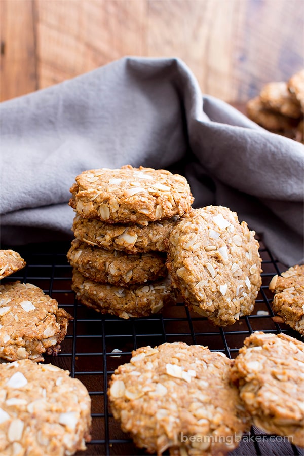 Stack of peanut butter cookies on a black cooking rack with a gray cloth behind it.