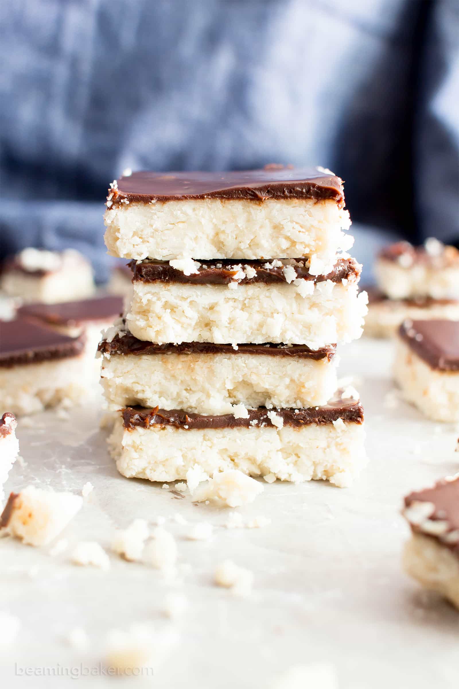 Vegan Coconut Chocolate Bars: this 5 ingredient coconut bars recipe yields thick, indulgent coconut bars enrobed in a velvety layer of rich chocolate. Healthy, Paleo, No Bake, Gluten Free. #Coconut #Bars #Vegan #Chocolate | Recipe at BeamingBaker.com