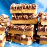 5 Ingredient Ultimate No Bake Chocolate Peanut Butter Bars (V, GF): The ULTIMATE chocolate peanut butter lover’s Reese’s peanut butter cup inspired dessert bar: thick layers of chocolate and peanut butter topped with crunchy peanuts and velvety chocolate drizzle. #Vegan #HealthyDesserts #ProteinRich #Snacks #GlutenFree #DairyFree #PeanutButter | Recipe on BeamingBaker.com