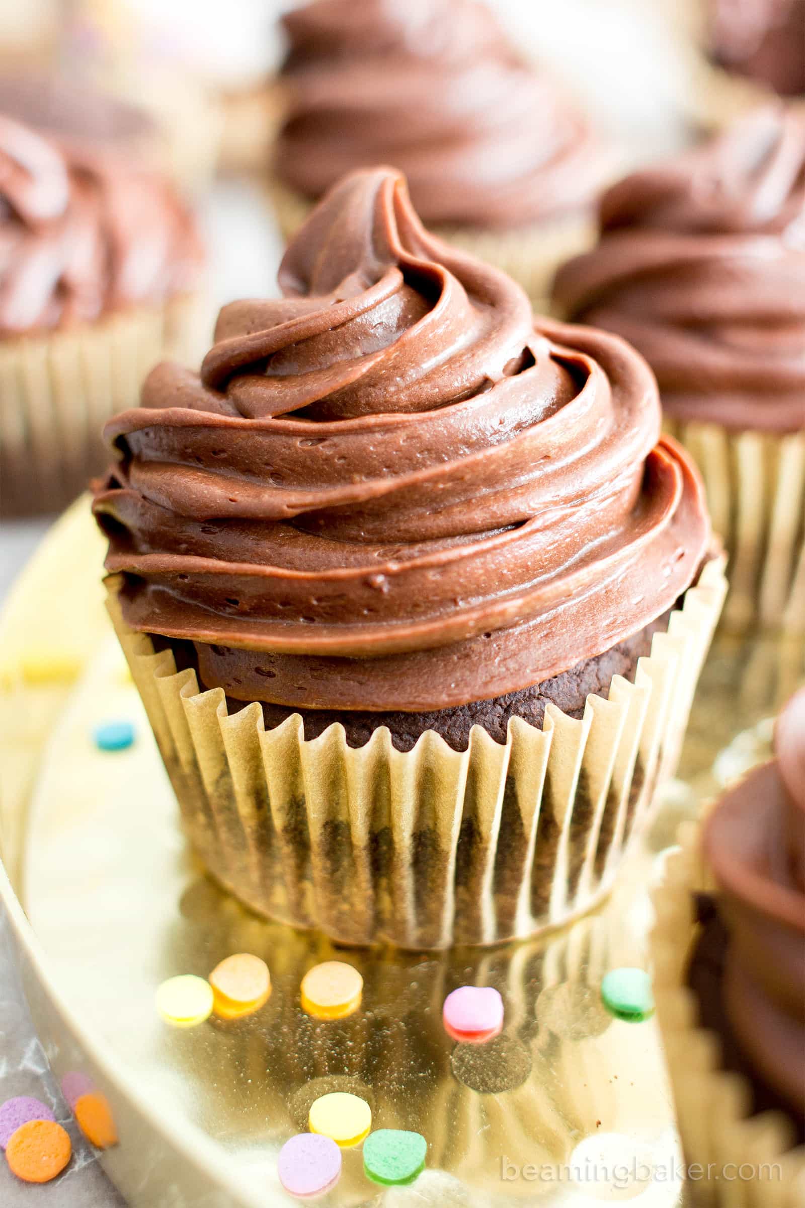 Oat flour chocolate cupcakes on a gold tray with sprinkles around it