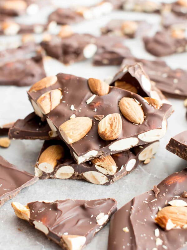 Stack of chocolate almond bark pieces on parchment paper