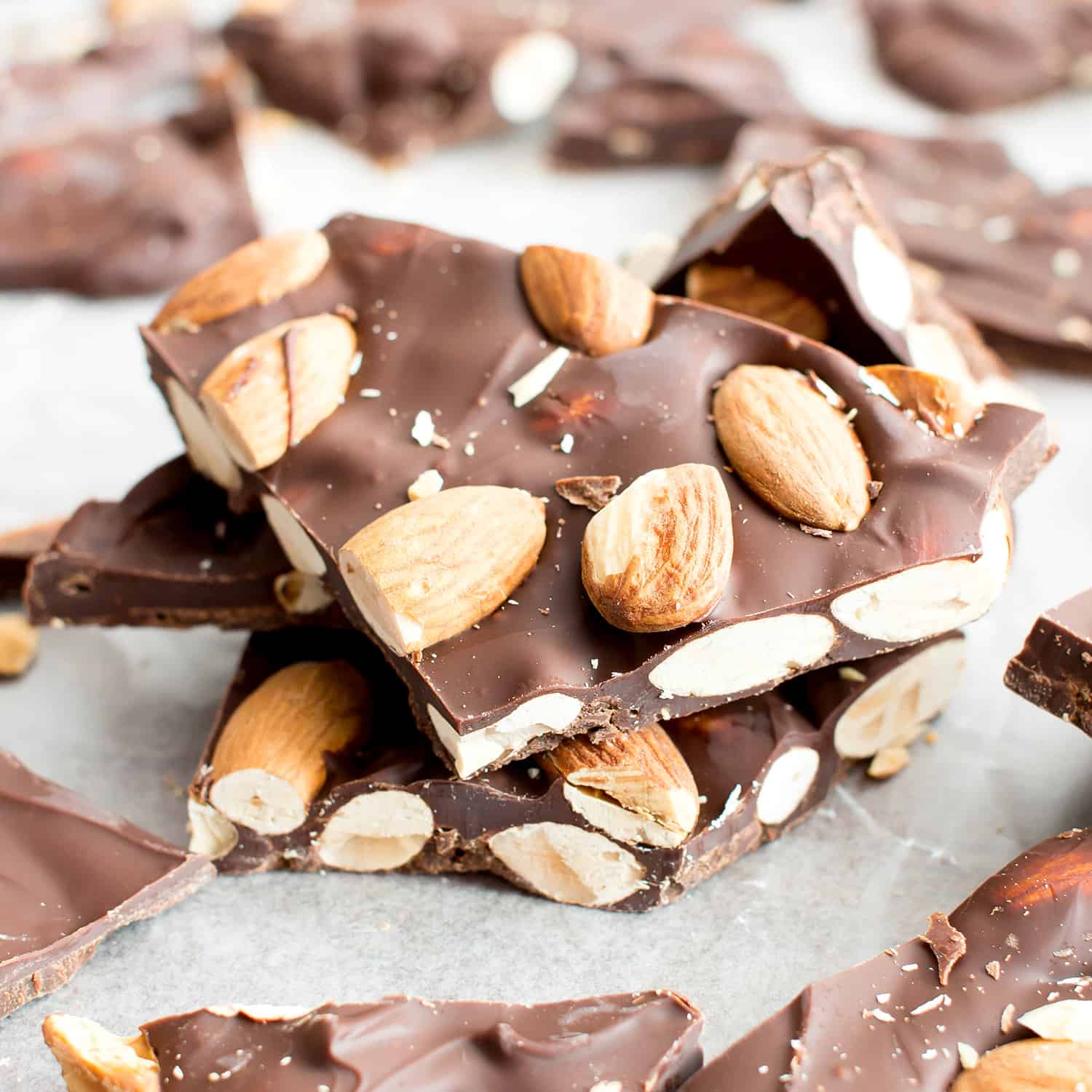 Stack of chocolate almond bark pieces on parchment paper