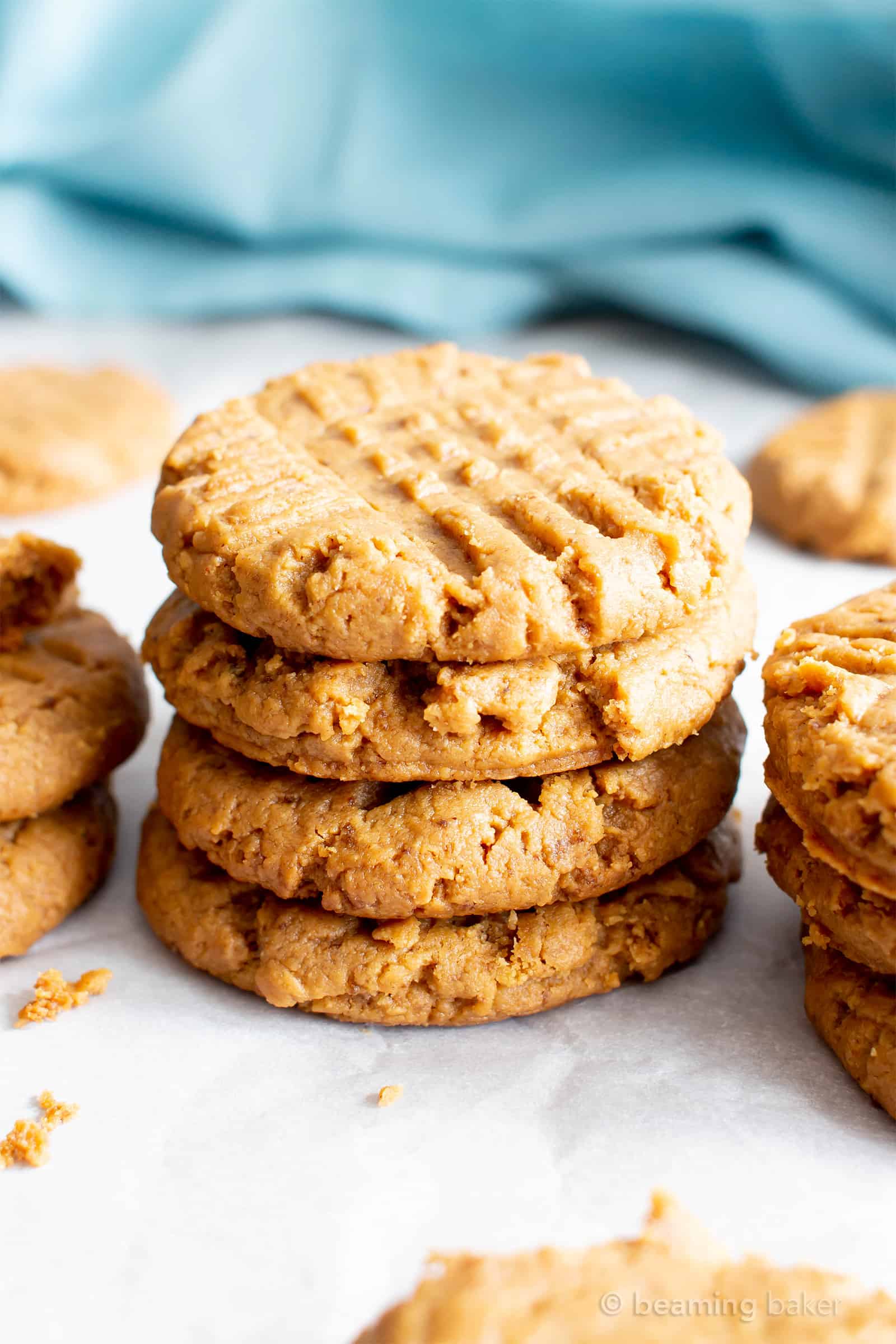 Stack of healthy peanut butter cookies with a blue cloth in the background.