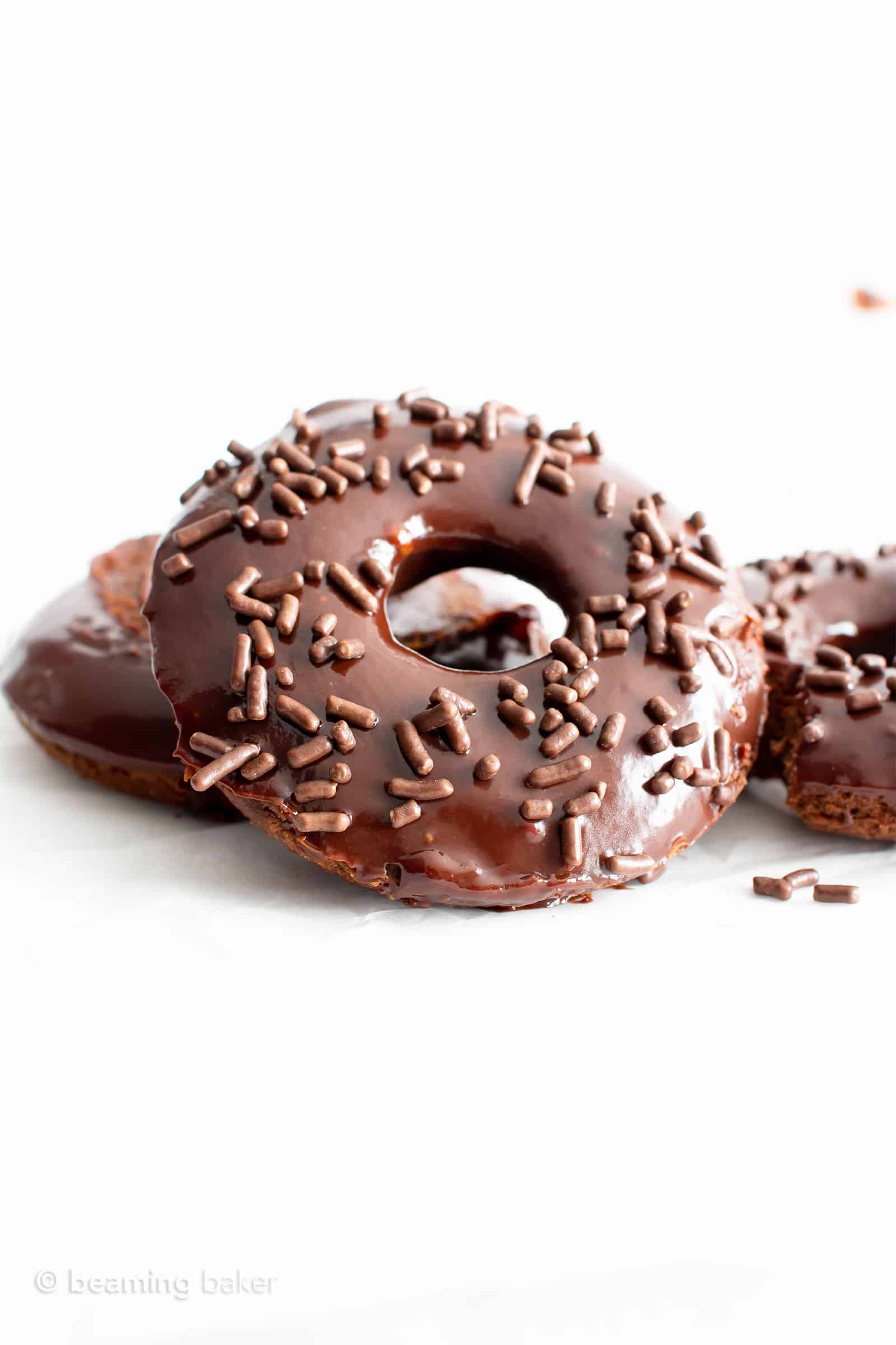 Vegan Gluten Free Donuts: soft ‘n fluffy vegan gf chocolate donuts topped with luxurious vegan chocolate glaze. The best gluten free vegan donut recipe! #GlutenFreeVegan #VeganGlutenFree #VeganDonuts #Doughnuts #Vegan | Recipe at BeamingBaker.com