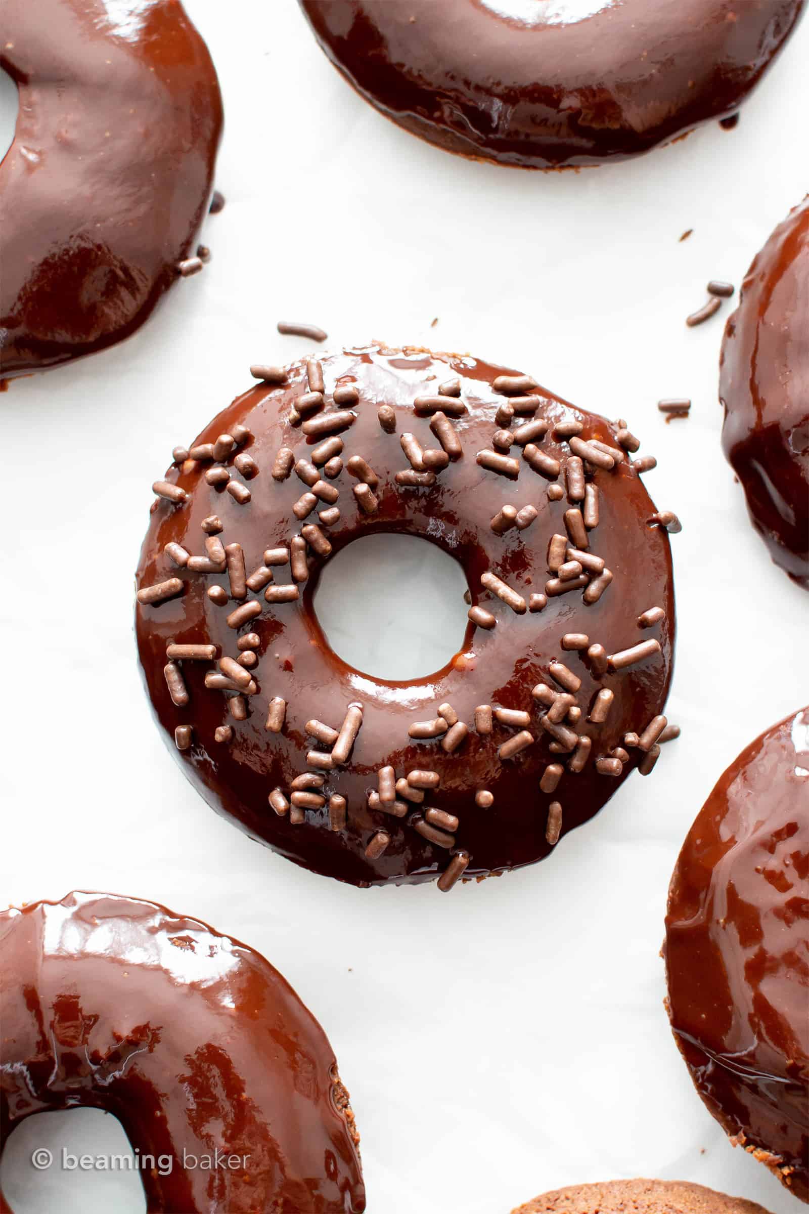 Vegan Gluten Free Donuts: soft ‘n fluffy vegan gf chocolate donuts topped with luxurious vegan chocolate glaze. The best gluten free vegan donut recipe! #GlutenFreeVegan #VeganGlutenFree #VeganDonuts #Doughnuts #Vegan | Recipe at BeamingBaker.com