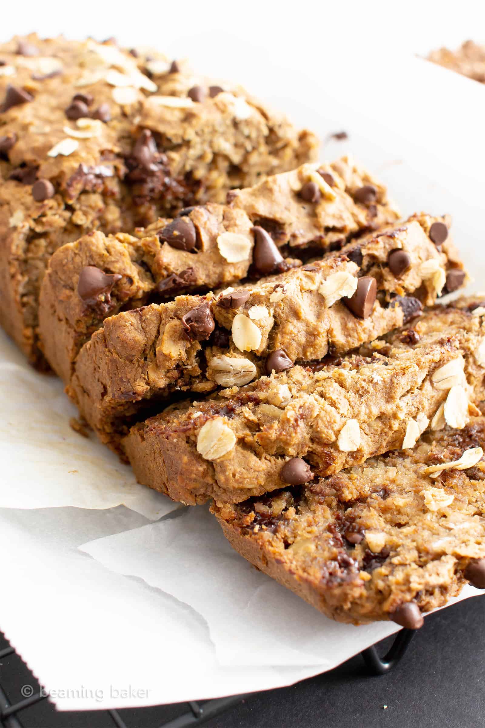 A spread out loaf of sliced Oatmeal Banana Bread topped with oats