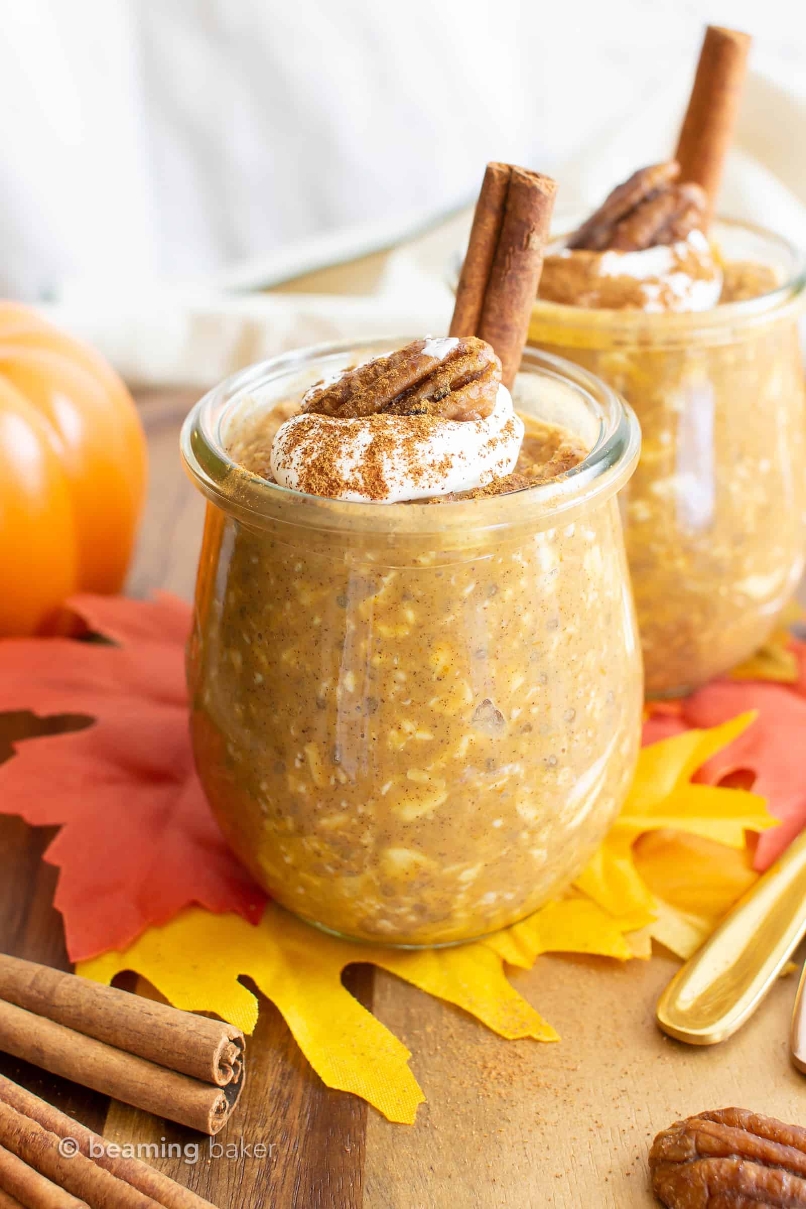 pumpkin overnight oats jars with whipped topping and a cinnamon stick