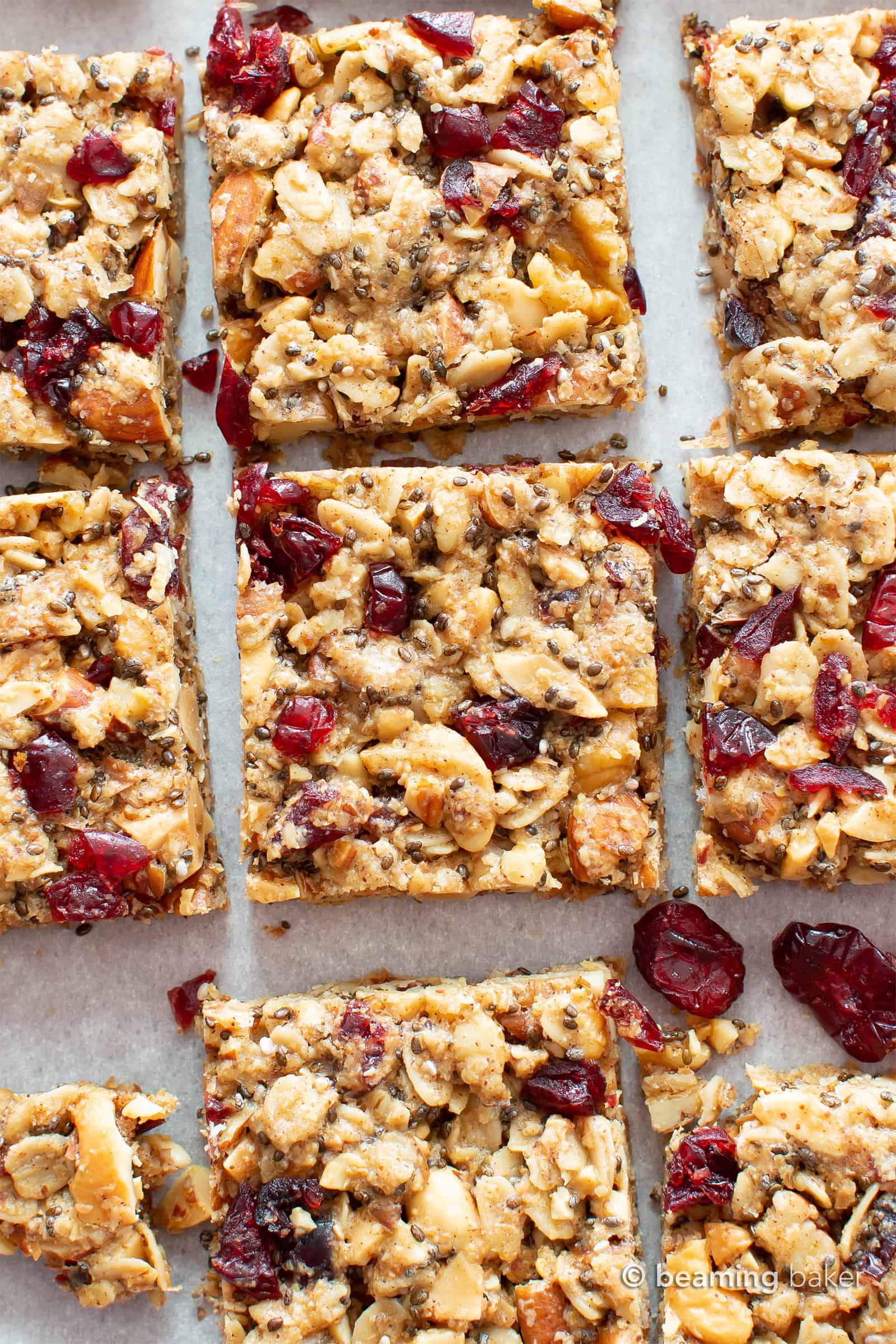 Overhead shot of vegan gluten free cranberry chia snack bars spread out on parchment paper