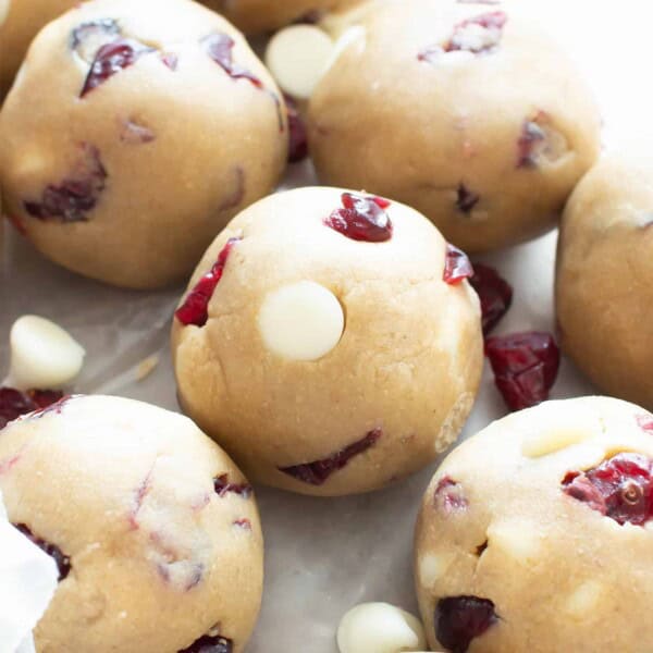 White Chocolate Cranberry Cookie Dough Bites (GF): this easy, no bake recipe for Vegan + Gluten Free cookie dough balls is deliciously sweet & tart! White chocolate chips & dried cranberries complement soft vegan cookie dough. Dairy-Free. #CookieDough #NoBake #Vegan #GlutenFree #Cranberries | Recipe at BeamingBaker.com