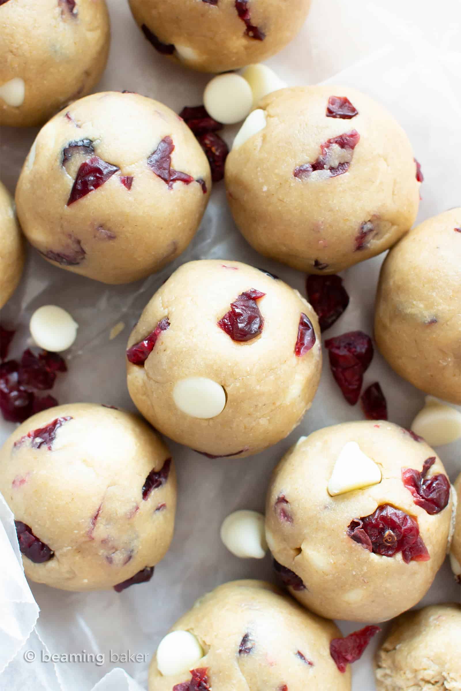 White Chocolate Cranberry Cookie Dough Bites (GF): this easy, no bake recipe for Vegan + Gluten Free cookie dough balls is deliciously sweet & tart! White chocolate chips & dried cranberries complement soft vegan cookie dough. Dairy-Free. #CookieDough #NoBake #Vegan #GlutenFree #Cranberries | Recipe at BeamingBaker.com