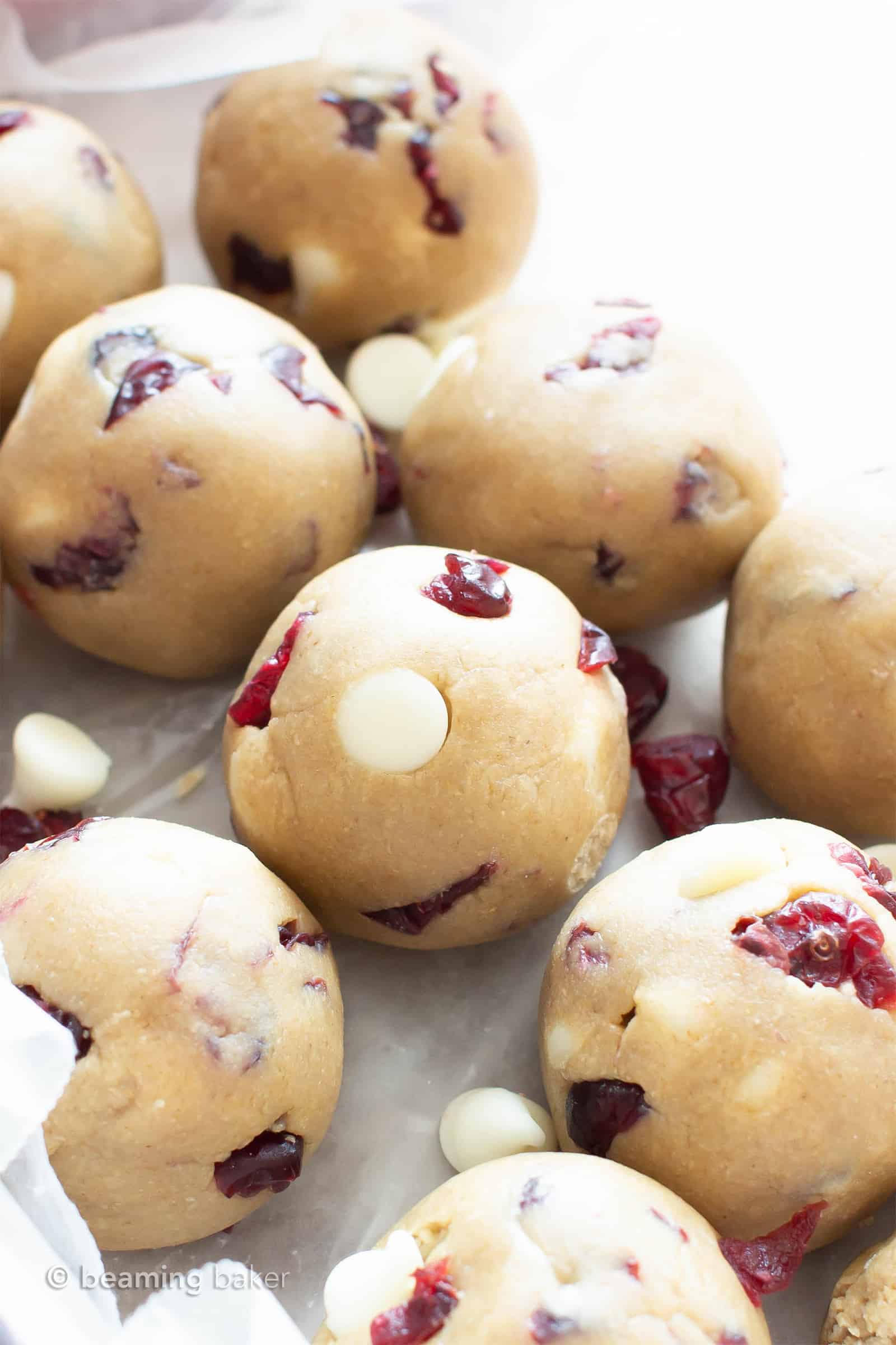 White Chocolate Cranberry Cookie Dough Bites (GF): this easy, no bake recipe for Vegan + Gluten Free cookie dough balls is deliciously sweet & tart! White chocolate chips & dried cranberries complement soft vegan cookie dough. Dairy-Free. #CookieDough #NoBake #Vegan #GlutenFree #Cranberries | Recipe at BeamingBaker.com