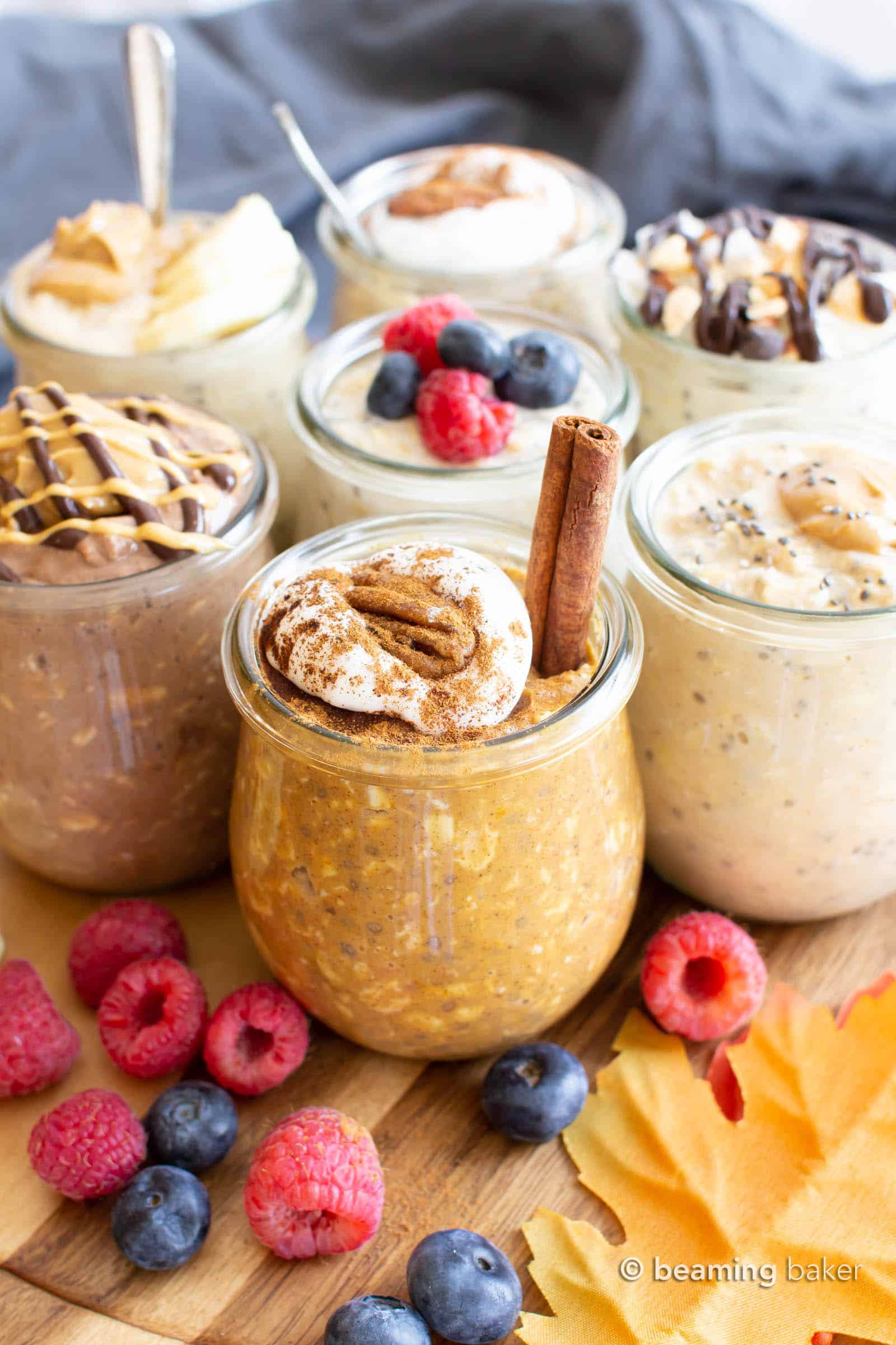 vegan pumpkin overnight oats in a mini jar with whipped topping and many jars of vegan overnight oats behind it