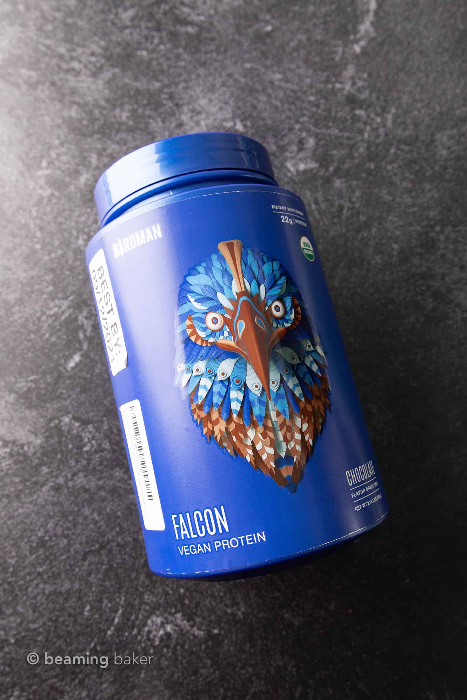 Container of Birdman vegan chocolate protein powder on grey background