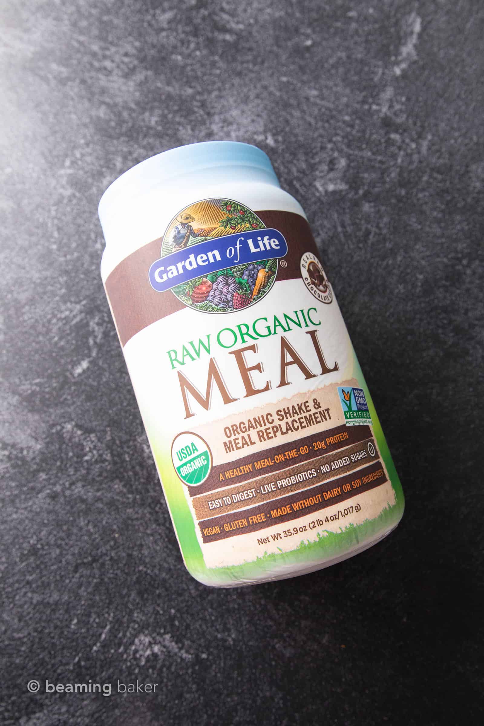 Container of Garden of Life meal replacement vegan chocolate protein powder on grey background