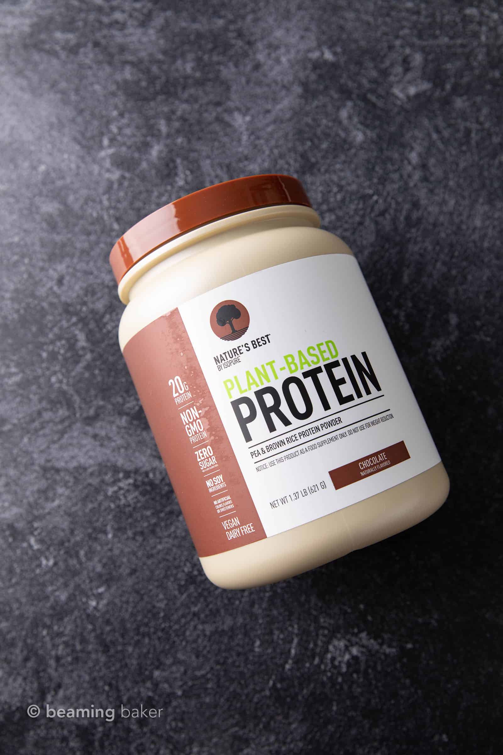 Container of Nature's Best vegan chocolate protein powder on grey background
