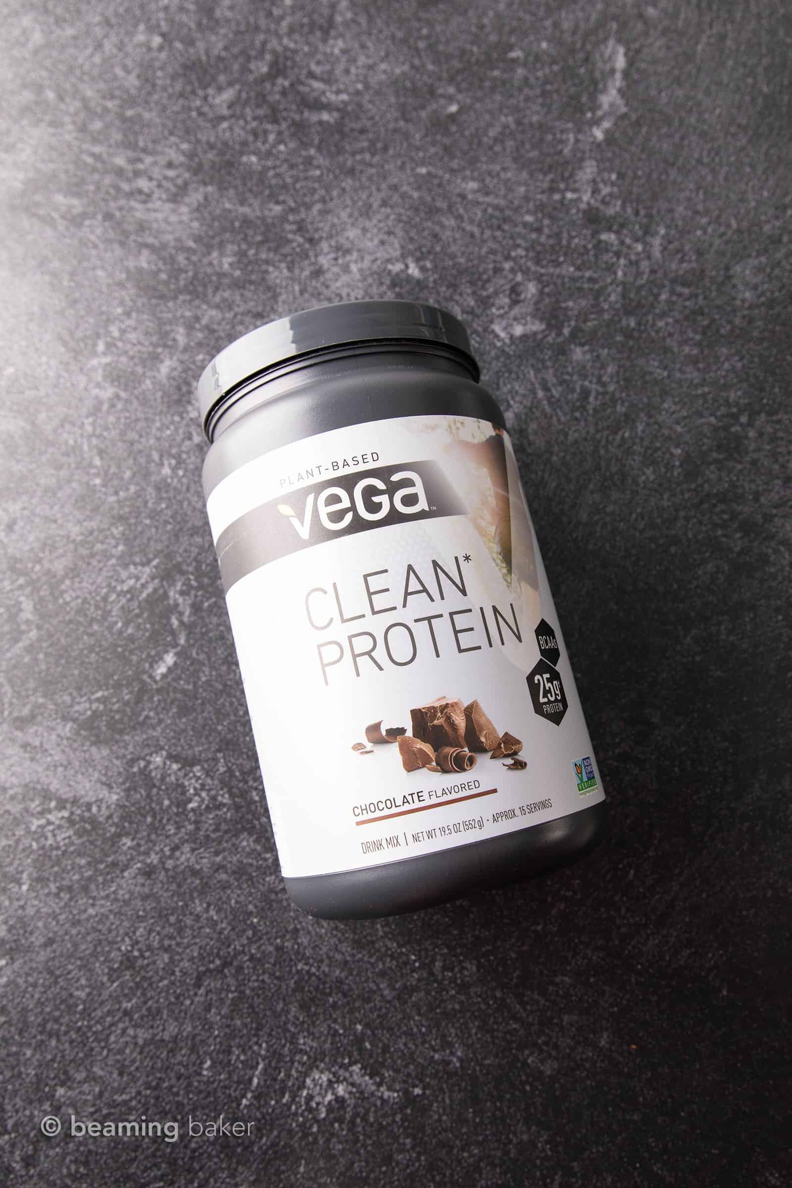 Container of Vega Clean Protein vegan chocolate protein powder on grey background