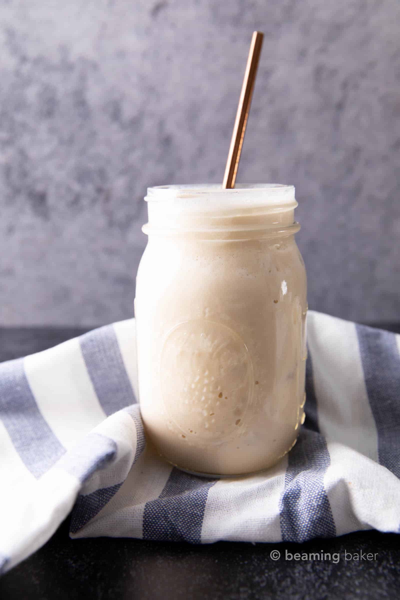 Protein shake in glass jar in front of blue and white striped cloth