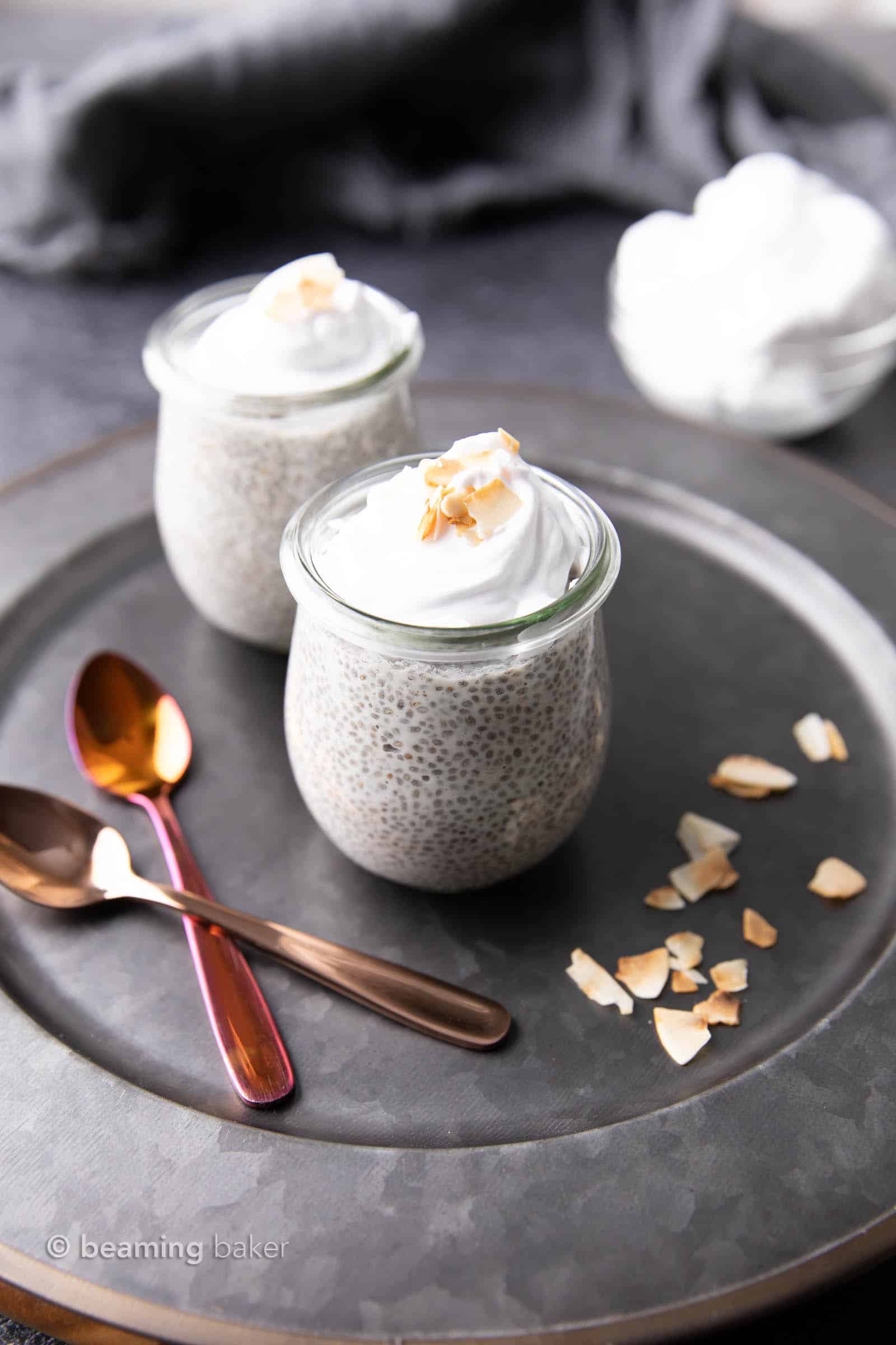 Angled shot of coconut milk chia pudding on a metal serving tray with a bowl of coconut whip in the background