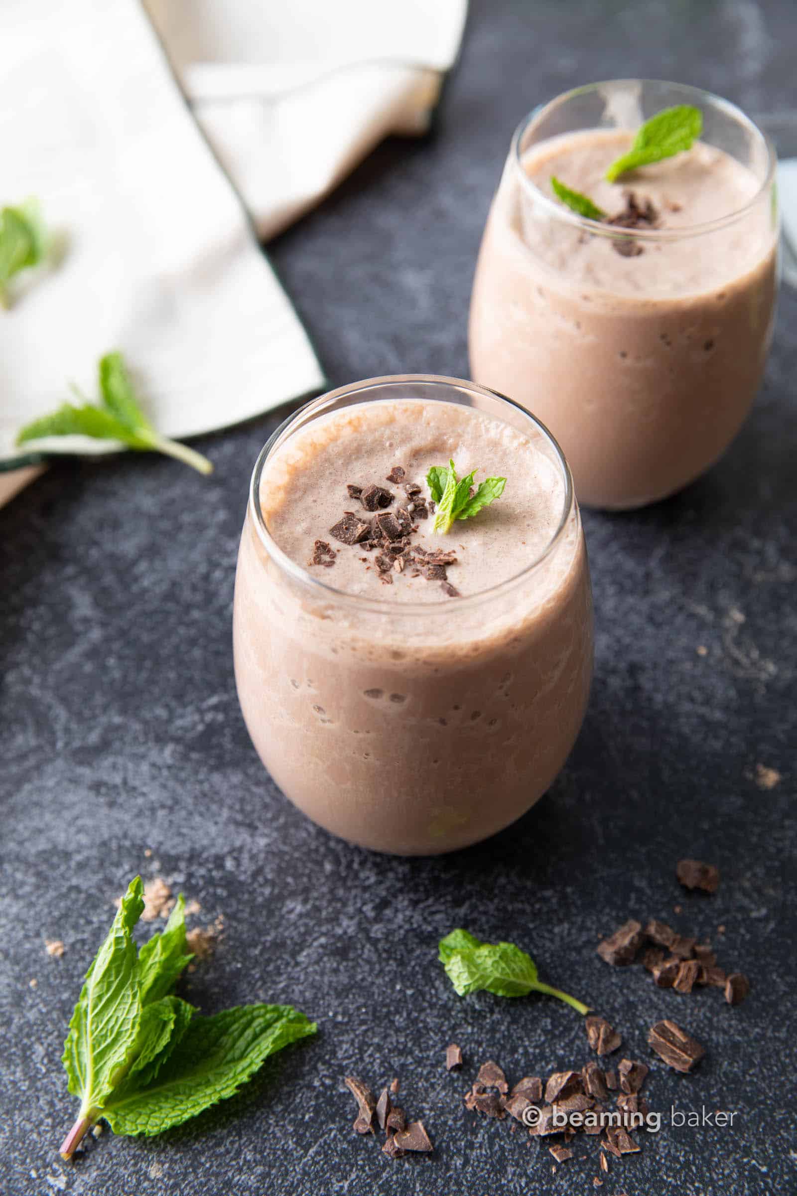 two mint chocolate protein shakes served with a garnish