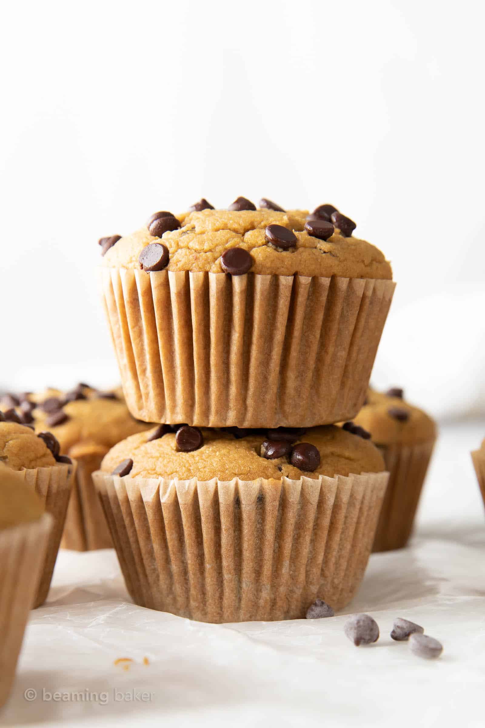 two healthy chocolate chip muffins in a stack near mini chocolate chips