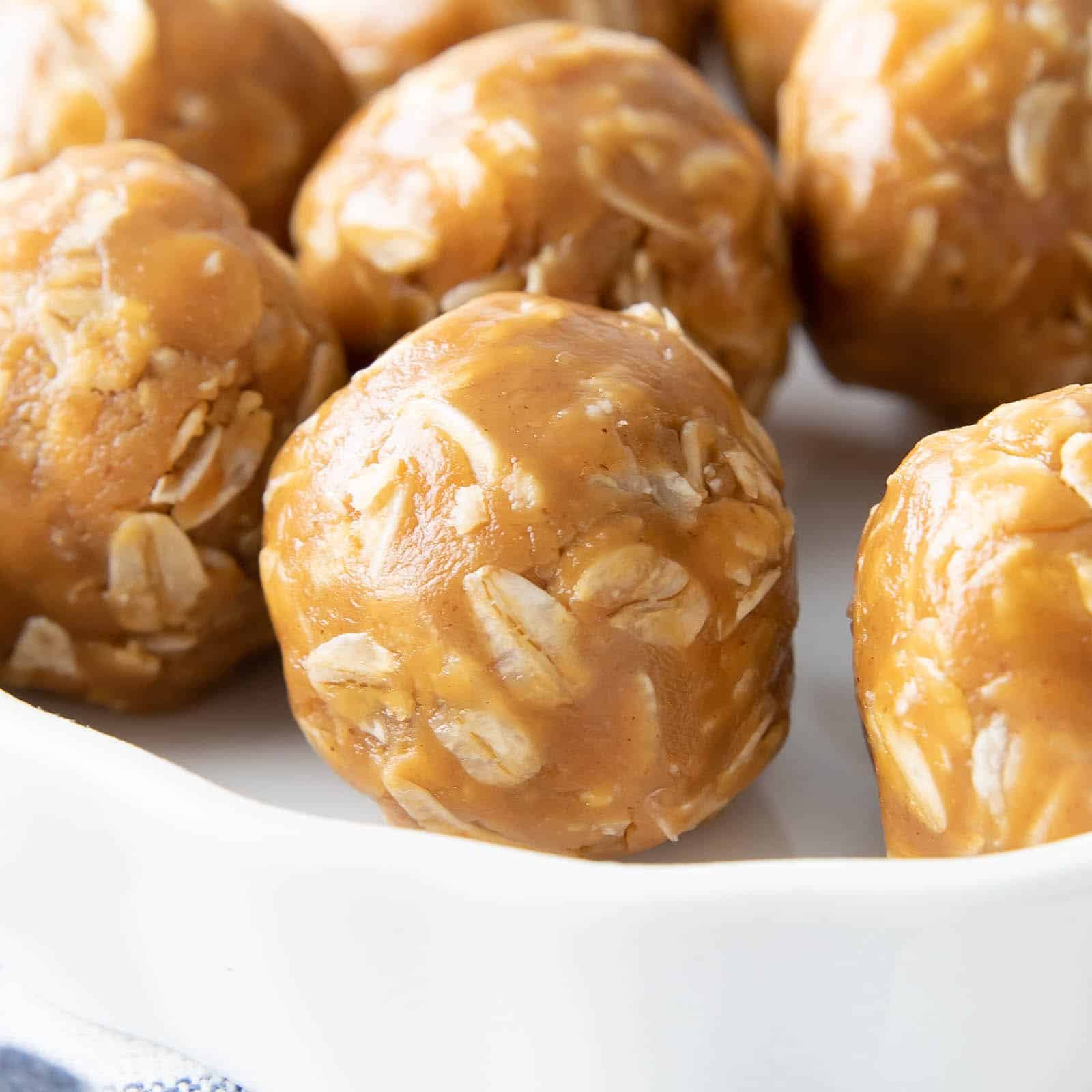 close up of peanut butter energy balls on a white plate.
