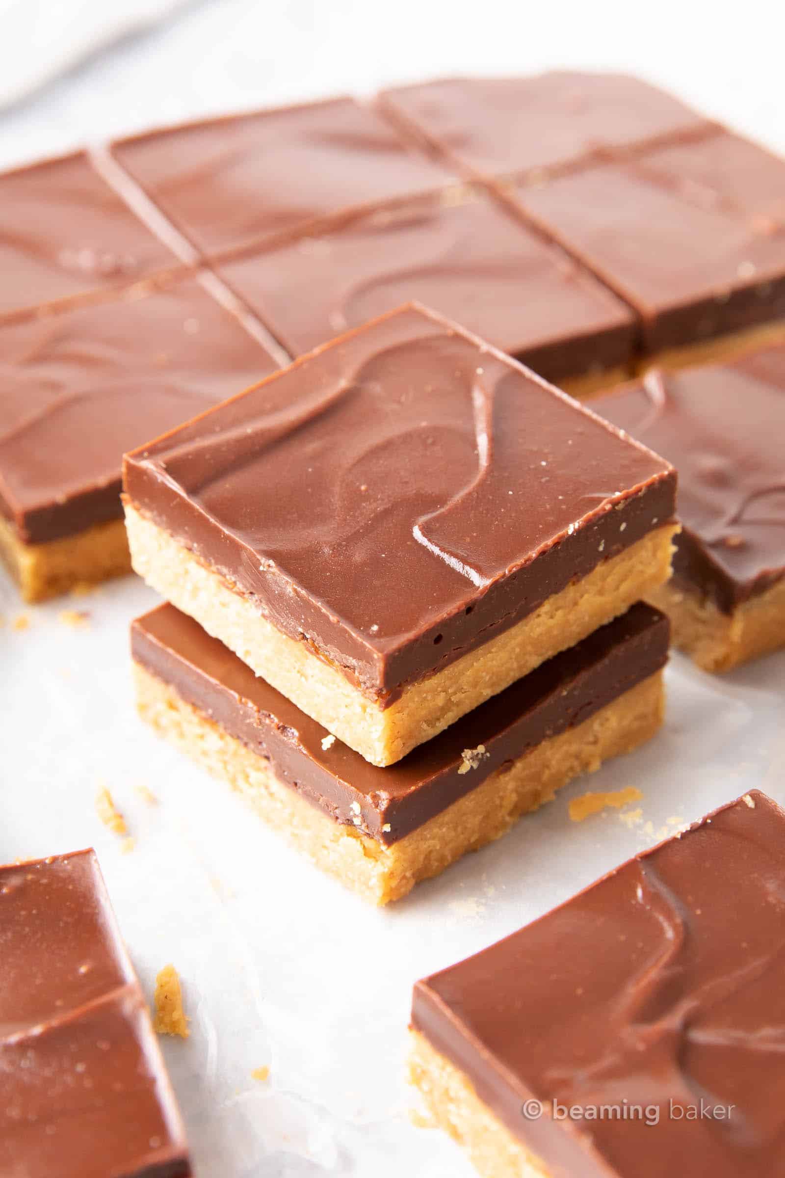 Keto Peanut Butter Bars: only 4 ingredients for soft ‘n dense no bake peanut butter bars topped with a thick layer of chocolate peanut butter. Sink your teeth into the best keto peanut butter chocolate bars! Like PB cups in bar form. #Keto #PeanutButter #LowCarb #Ketogenic #Chocolate | Recipe at BeamingBaker.com