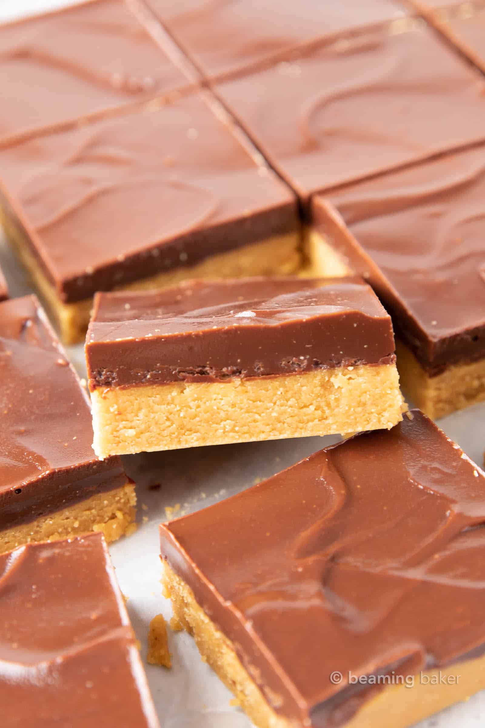 Keto Peanut Butter Bars: only 4 ingredients for soft ‘n dense no bake peanut butter bars topped with a thick layer of chocolate peanut butter. Sink your teeth into the best keto peanut butter chocolate bars! Like PB cups in bar form. #Keto #PeanutButter #LowCarb #Ketogenic #Chocolate | Recipe at BeamingBaker.com