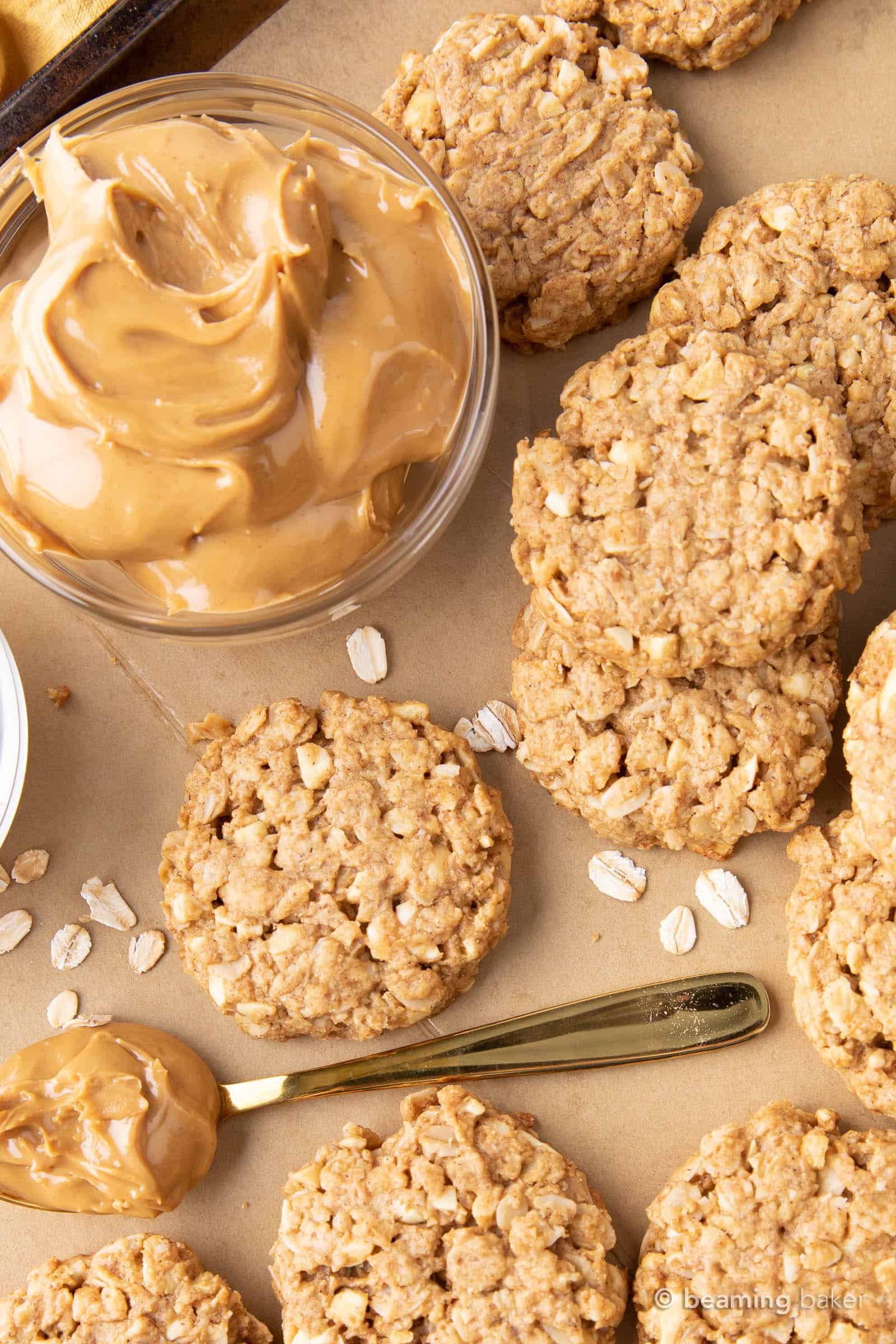 mountains of healthy peanut butter oatmeal cookies and a gold spoon filled with peanut butter