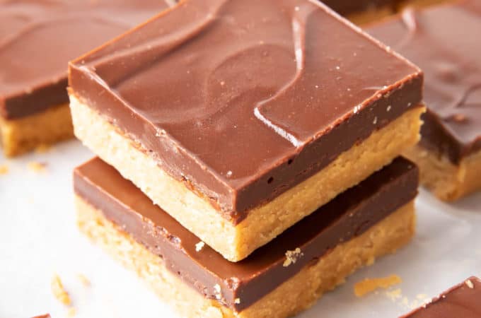 Keto Peanut Butter Bars: only 4 ingredients for soft ‘n dense no bake peanut butter bars topped with a thick layer of chocolate peanut butter. Sink your teeth into the best keto peanut butter chocolate bars! Like PB cups in bar form. #Keto #PeanutButter #LowCarb #Ketogenic #Chocolate | Recipe at BeamingBaker.com