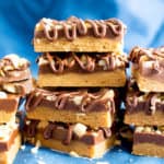 No Bake Peanut Butter Bars (Healthy): the ultimate healthy no bake peanut butter bars—just 5 ingredients, with thick layers of chocolate & peanut butter, a crunchy topping & velvety chocolate drizzle. #PeanutButterBars #Healthy #NoBake #Chocolate #PeanutButter | Recipe at BeamingBaker.com