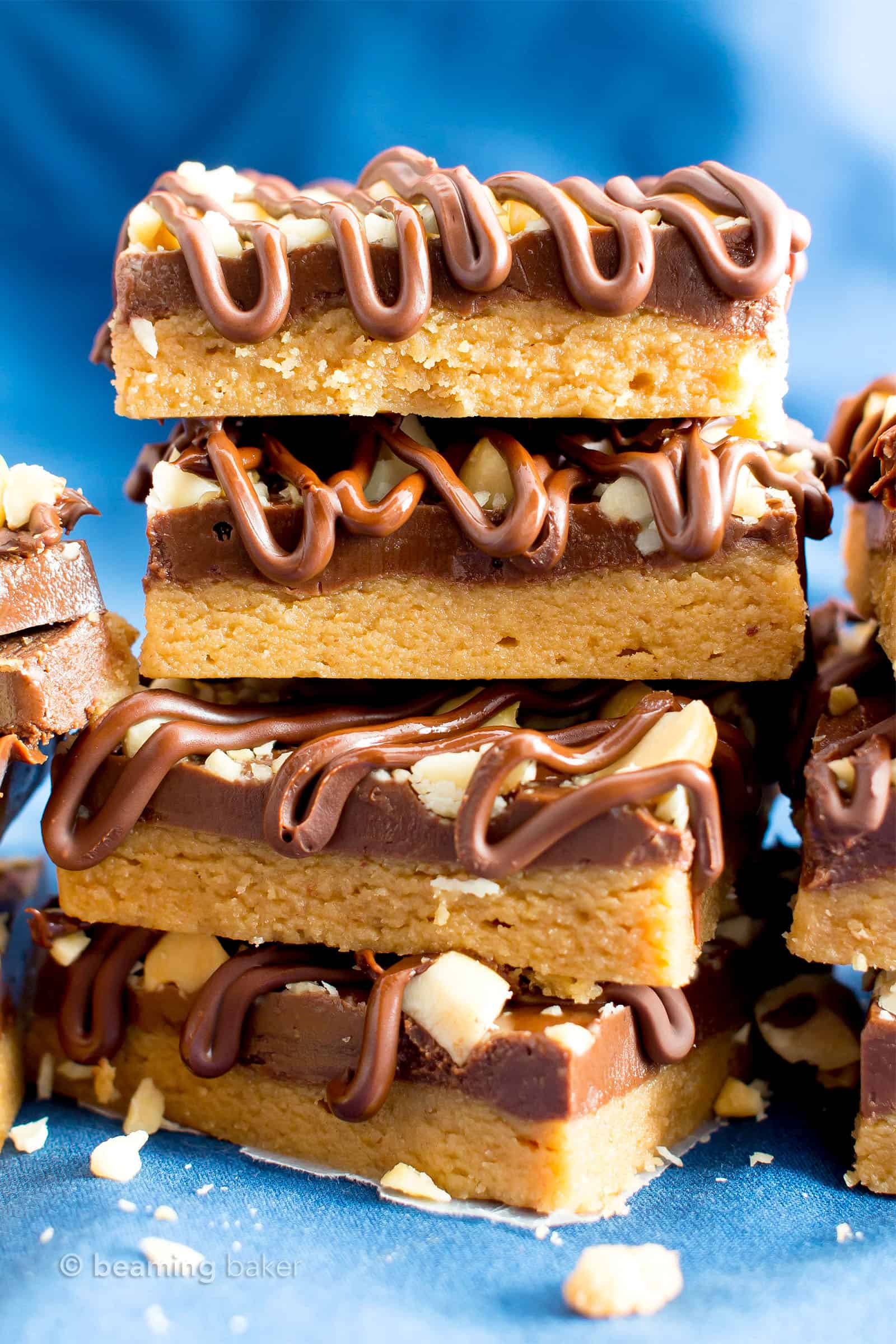 No Bake Peanut Butter Bars (Healthy): the ultimate healthy no bake peanut butter bars—just 5 ingredients, with thick layers of chocolate & peanut butter, a crunchy topping & velvety chocolate drizzle. #PeanutButterBars #Healthy #NoBake #Chocolate #PeanutButter | Recipe at BeamingBaker.com