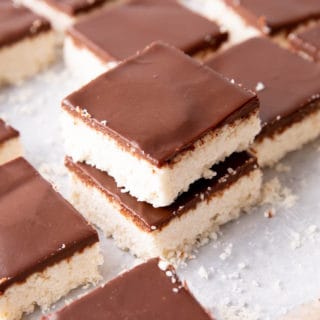 Keto Coconut Chocolate Bars: decadent keto coconut bars topped with a velvety layer of rich dark chocolate. The best keto coconut chocolate bars—Low Carb, super easy to make and mouthwateringly good! #Keto #Coconut #LowCarb #KetoBars | Recipe at BeamingBaker.com