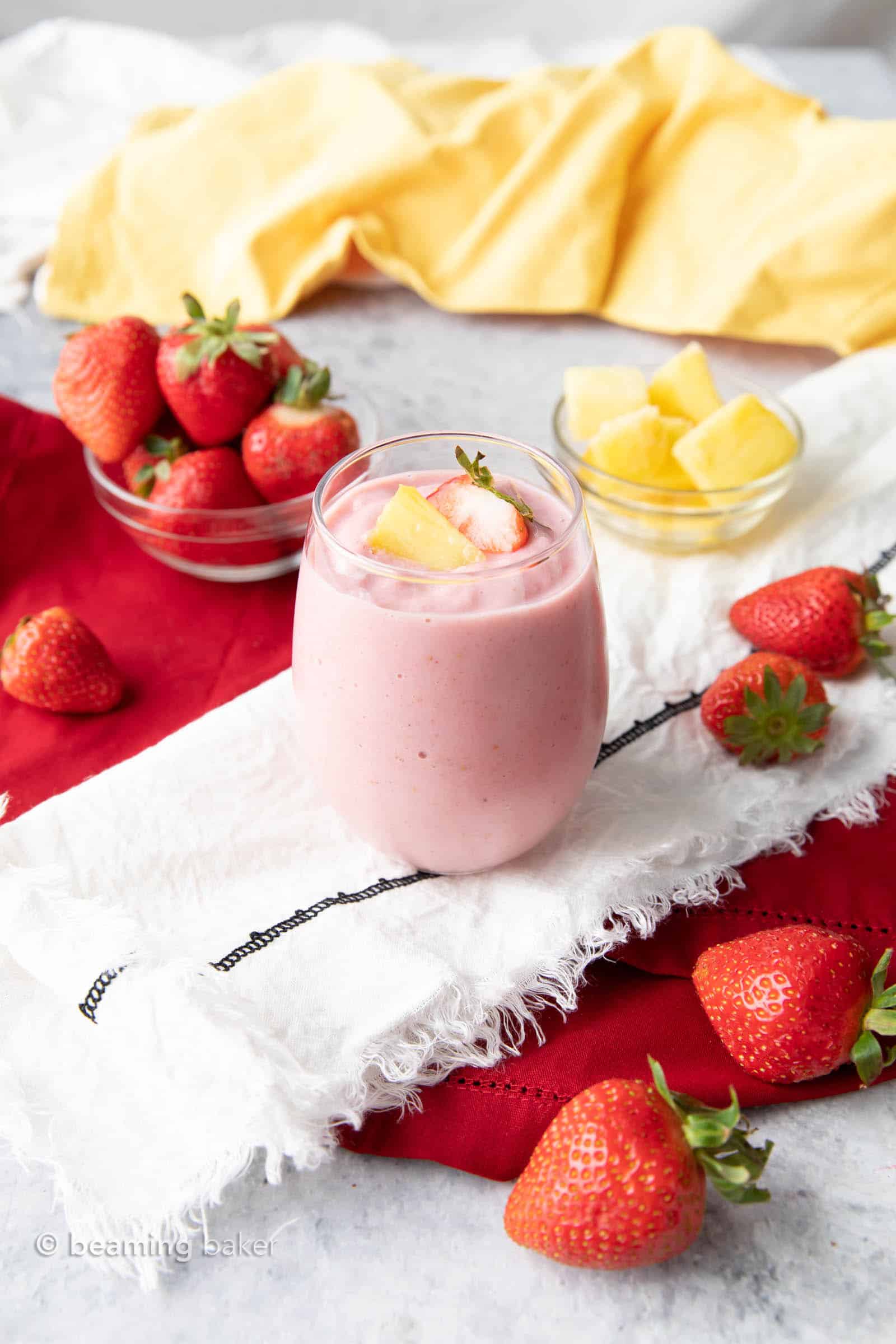 Fresh pineapple strawberry toppings served with this Strawberry Pineapple smoothie on a tablecloth