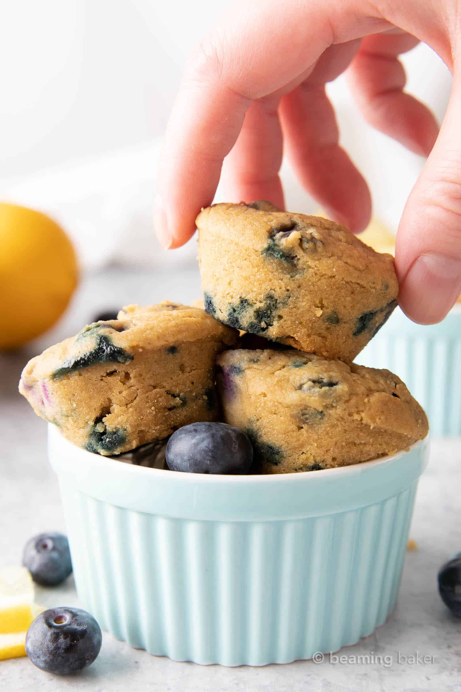 Mini Vegan Lemon Blueberry Muffins: super cute, mini-sized moist vegan lemon blueberry muffins. Bright blueberry & fresh lemon flavor packed into tiny vegan muffins! #Vegan #Lemon #Blueberry #Muffins | Recipe at BeamingBaker.com