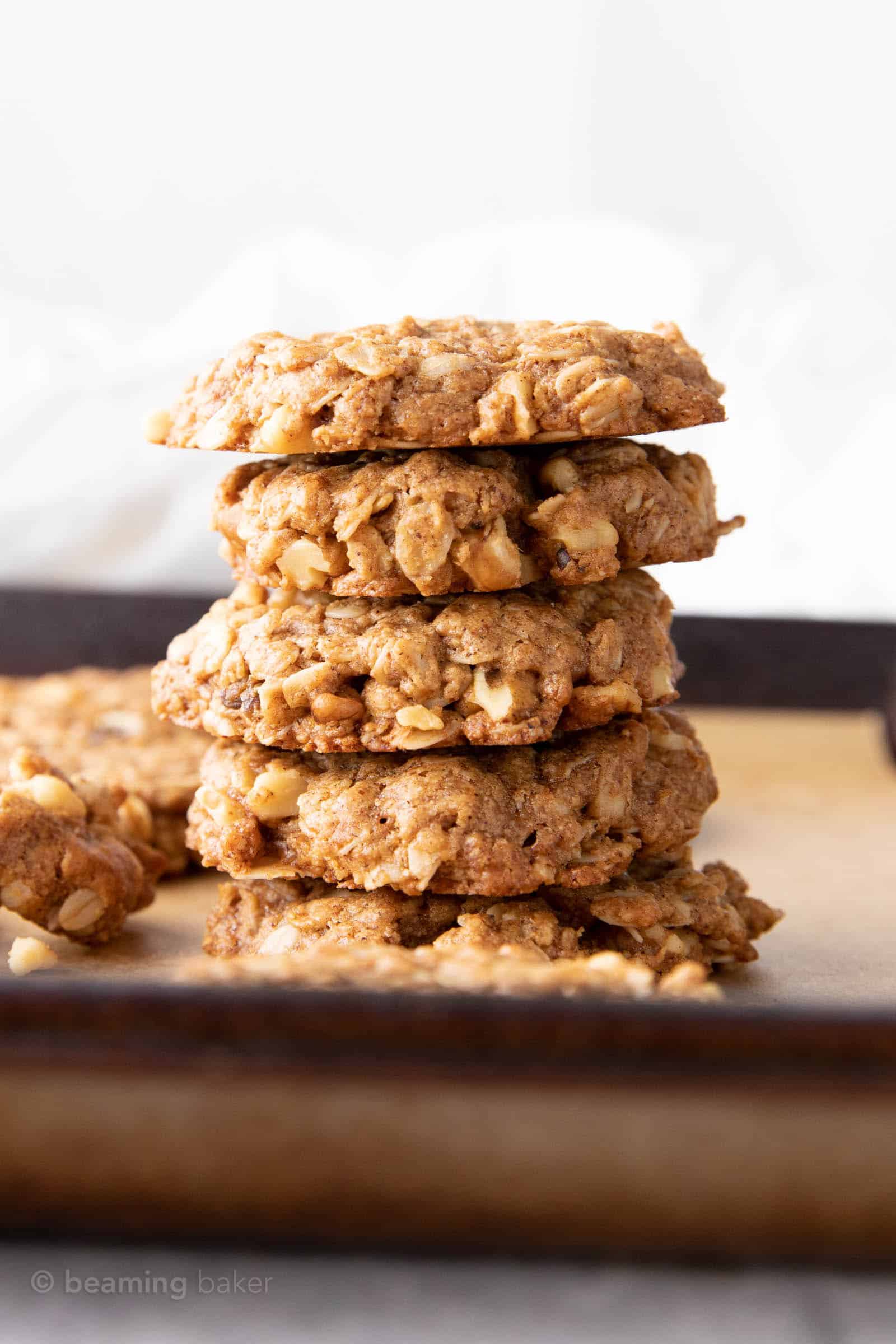 Tall stack of cinnamon oatmeal cookies on a cookie sheet.