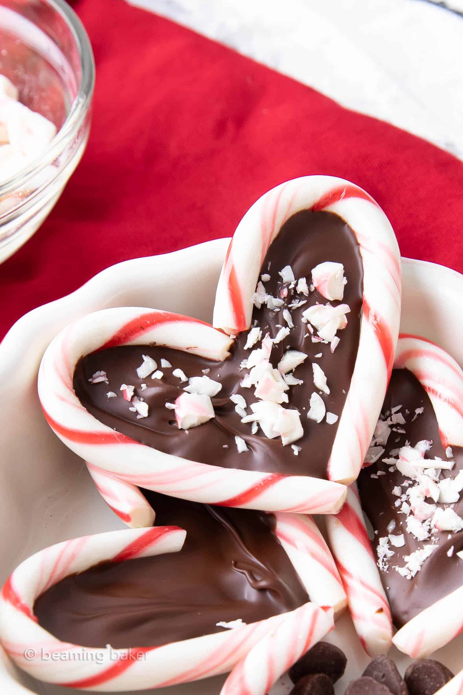 Super closeup shot of candy cane hearts in a bowl with chocolate chips and more candy canes as garnish