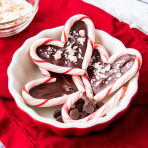 Candy cane hearts served in a festive red bowl.