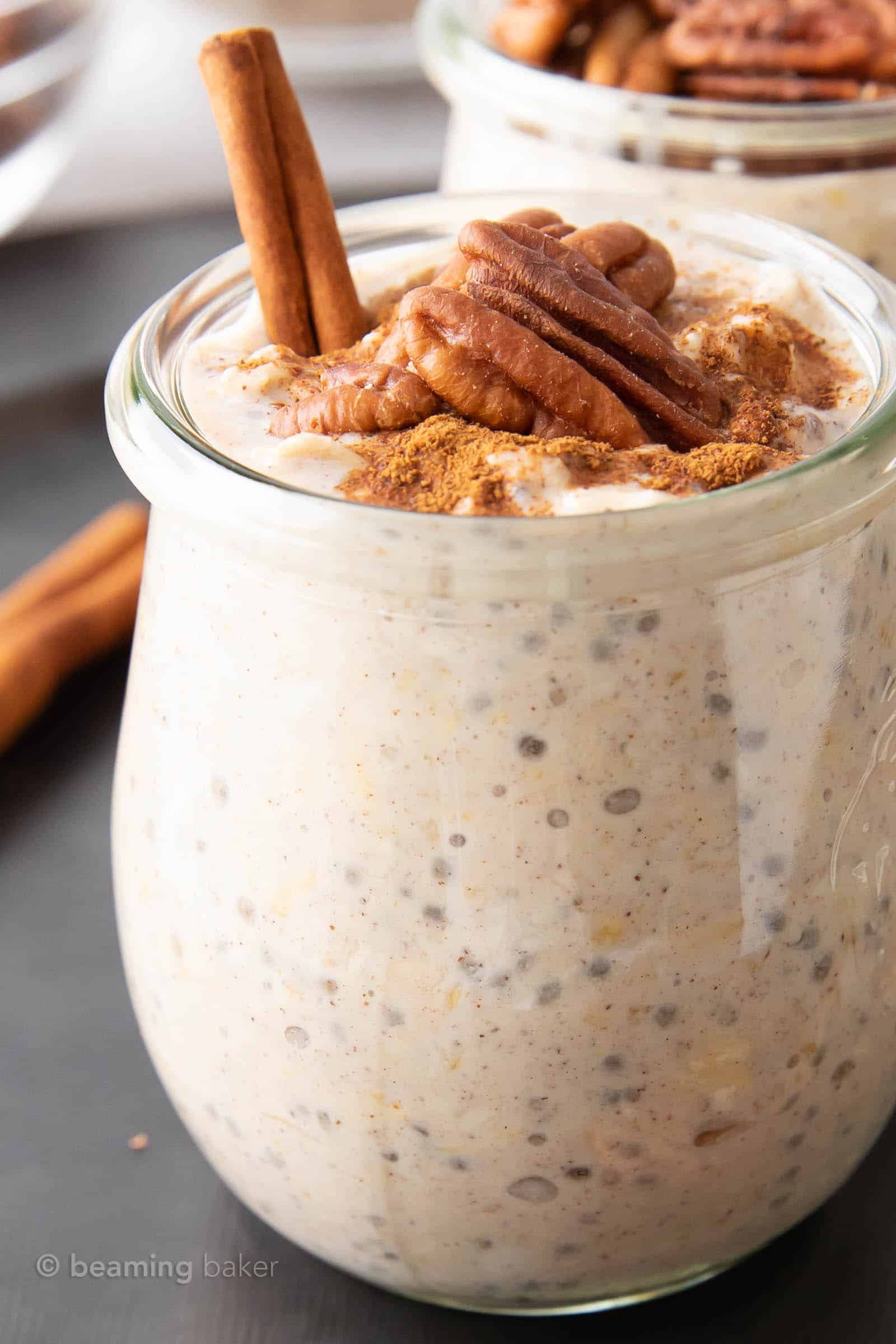 Super closeup jar of maple pecan overnight oats topped with cinnamon stick and pecans