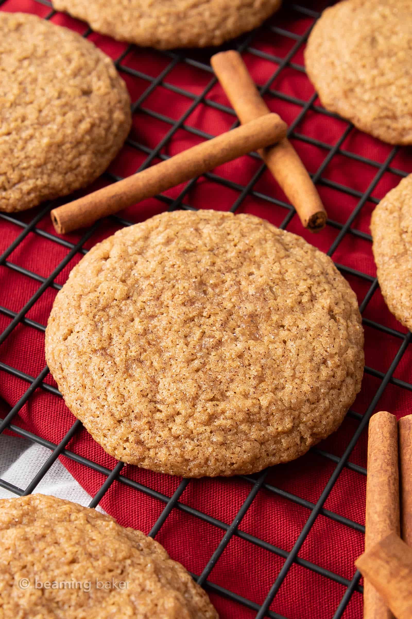 super closeup of vegan cinnamon cookies on a cookie cooling rack over a bright red cloth