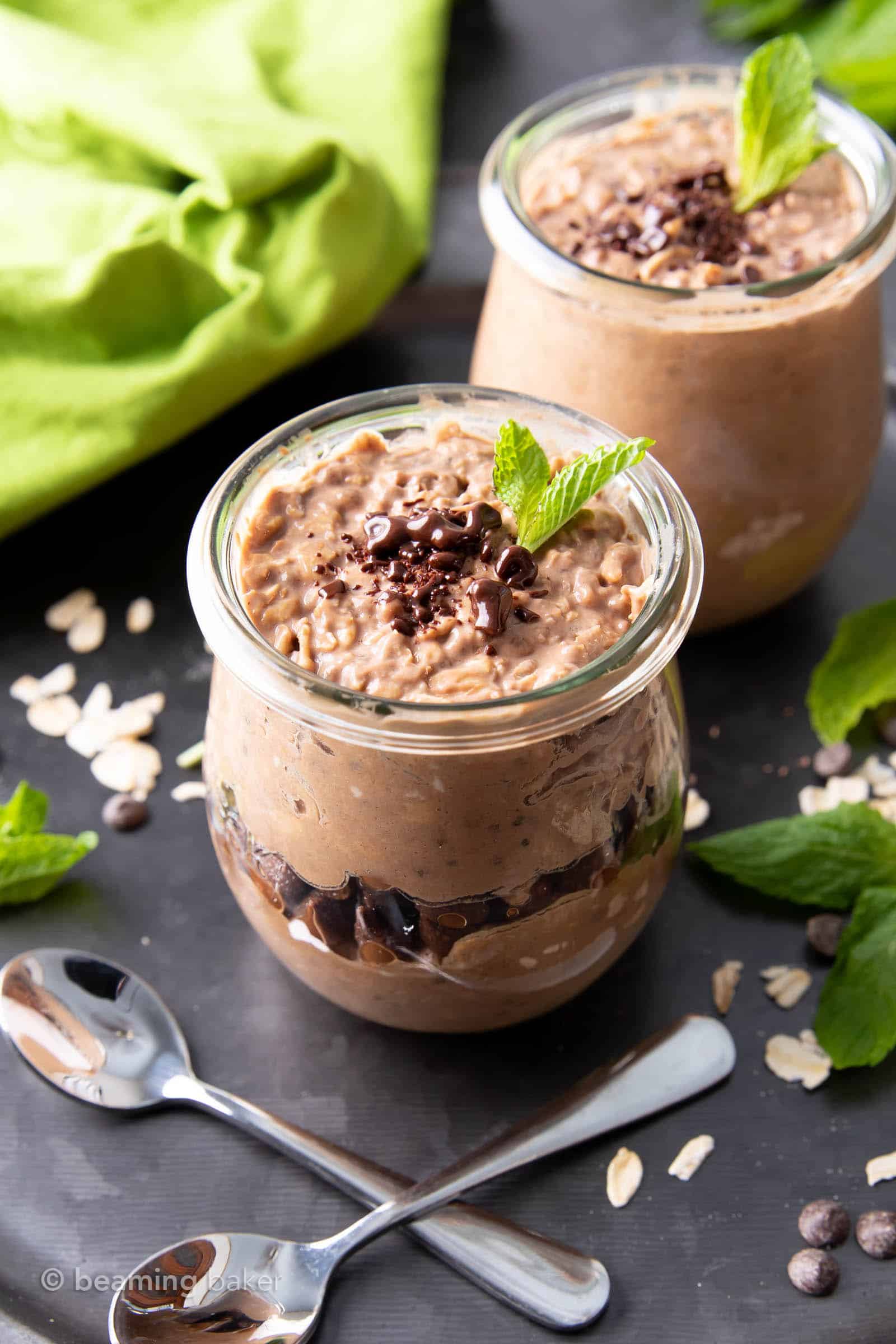 Closeup of mint chocolate chip overnight oats into two jars garnished with mint