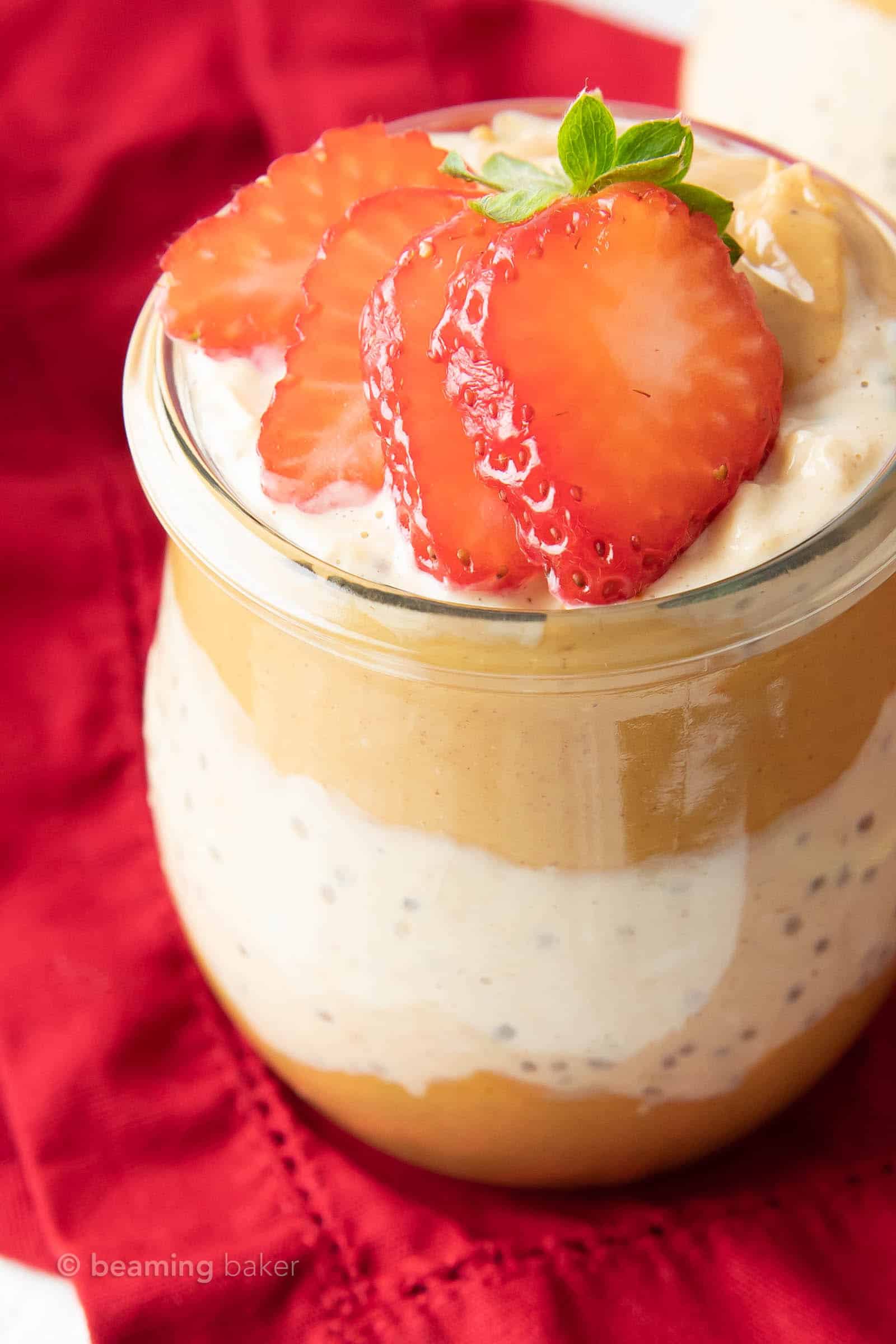 Fresh, sliced strawberries atop layers of peanut butter and overnight oats with peanut butter