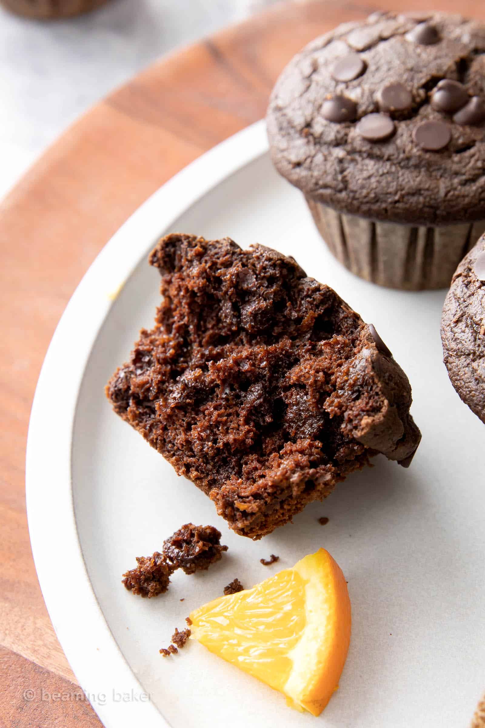 Closeup half of a chocolate orange muffin bursting with melty chocolate chips